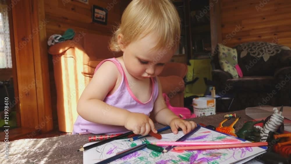 Sweet little girl draws with colored pencils Sweet little girl draws with colored pencils