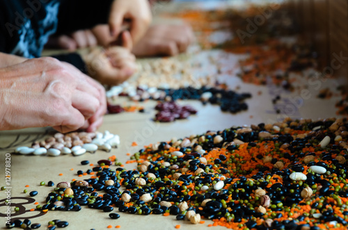 hands of adults and children playing with legumes during a workshop about nutrition