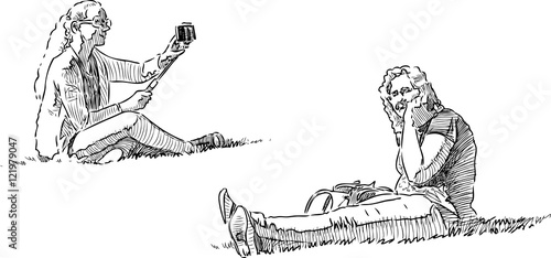 women have a rest on a lawn in the city park