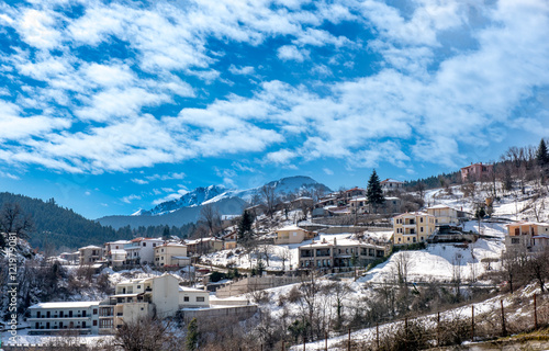 Mountainous snowy village under cloudscape on Plastira lake in central Greece