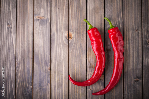 Red hot chili peppers on wood background