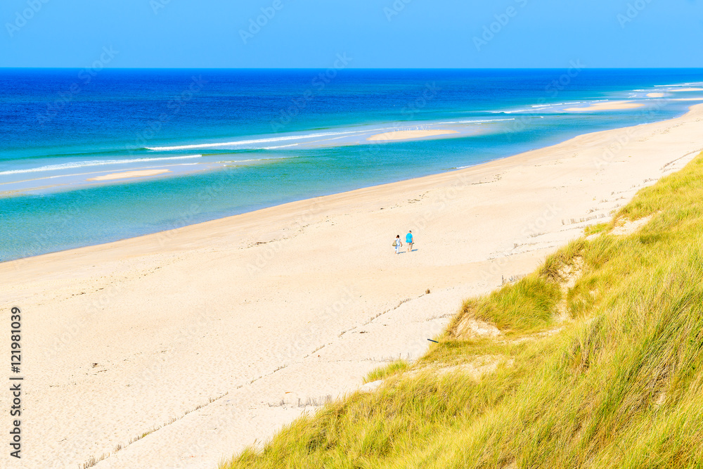Couple of people walking on idyllic beach between Rantum and Hornum villages on Sylt island, Germany