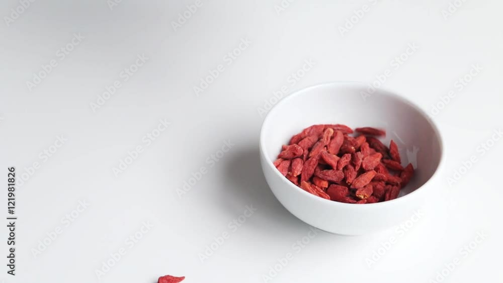 Putting goji berries - Lycium barbarum - in a bowl. White background. Goji berries from south China - whole fruit or its extracts are said to have numerous implied health effects. Putting goji berries - Lycium barbarum - in a bowl. White background. Goji berries from south China - whole fruit or its extracts are said to have numerous implied health effects.