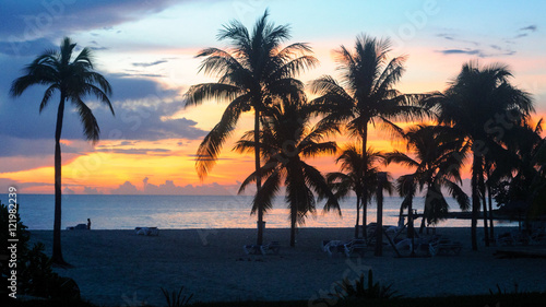 Atardecer y puesta de sol   con siluetas de palmeras en Cuba