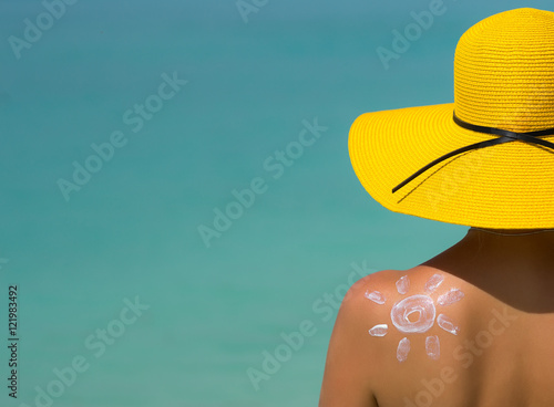 Woman with sun-shaped sun cream on beach photo