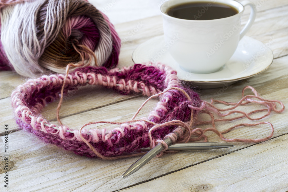 Skeins of wool and knitting needles on wooden background