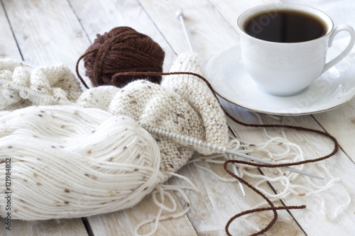 Skeins of wool and knitting needles on wooden background