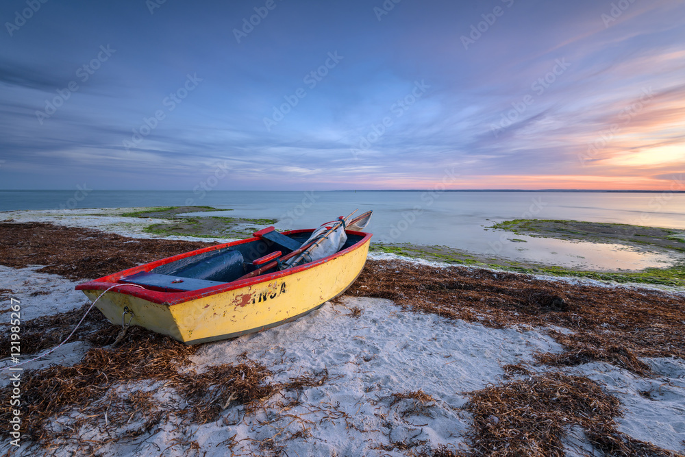 An old wooden fishing boat on a sandy beach. Poland.