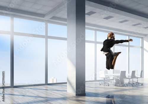 Dancing businesswoman in office . Mixed media