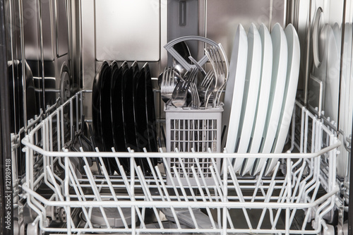 Dishes after washing in modern dishwasher machine photo