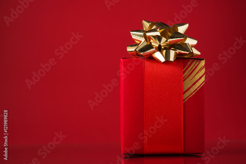 Red gift box on red background with space for text. Merry christmas card. Winter holidays. Xmas. Valentine's day.