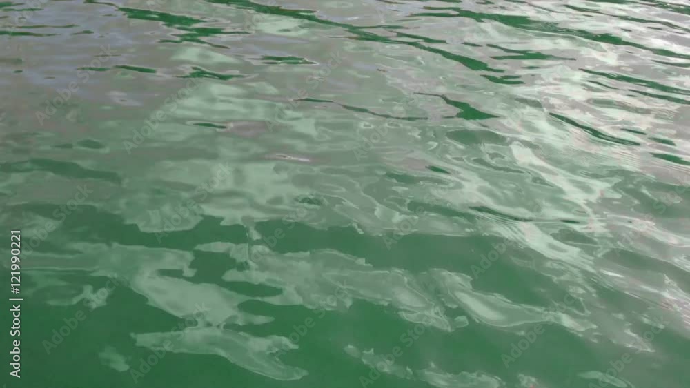 Water surface with waves glittering in the sun. Sun glares reflected. Water surface with waves glittering in the sun. Sun glares reflected.