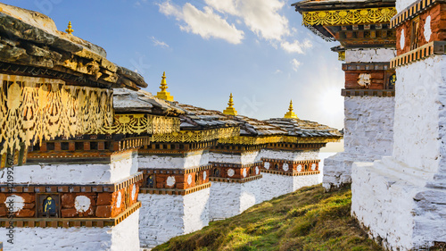 Dochula pass 108 chortens (Asian stupas) is the memorial in honour of the Bhutanese soldiers in the Timpu city with the grass landscape and cloudy sky background, Bhutan photo