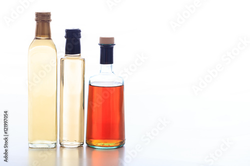 Bottles of vinegar on white background