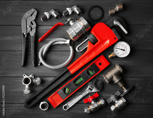 Plumber tools on a gray wooden background photo