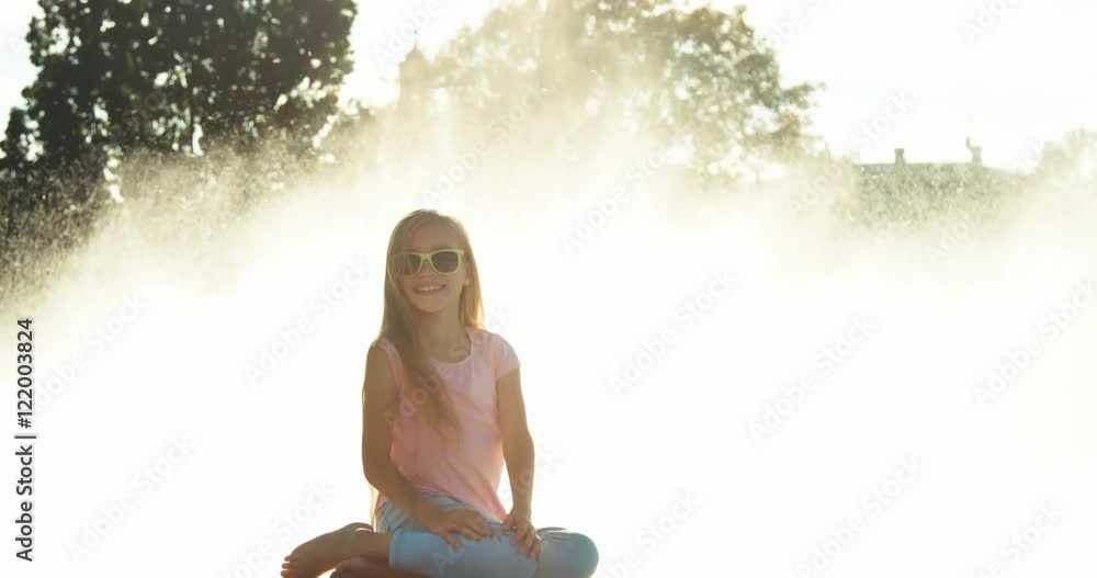 Child girl near fountain background at sunny day Child girl near fountain background at sunny day