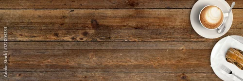 Obraz Filiżanka cappuccino z ciastem na nieociosanym drewnianym stole