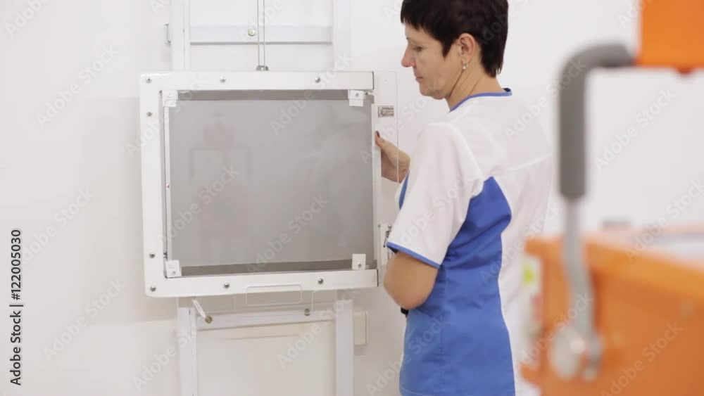 A woman setting up x-ray machine in clinic A woman setting up x-ray machine in clinic