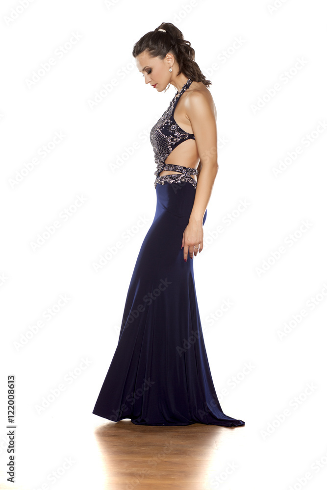 young beautiful woman posing in a long blue dress on a white background young beautiful woman posing in a long blue dress on a white background