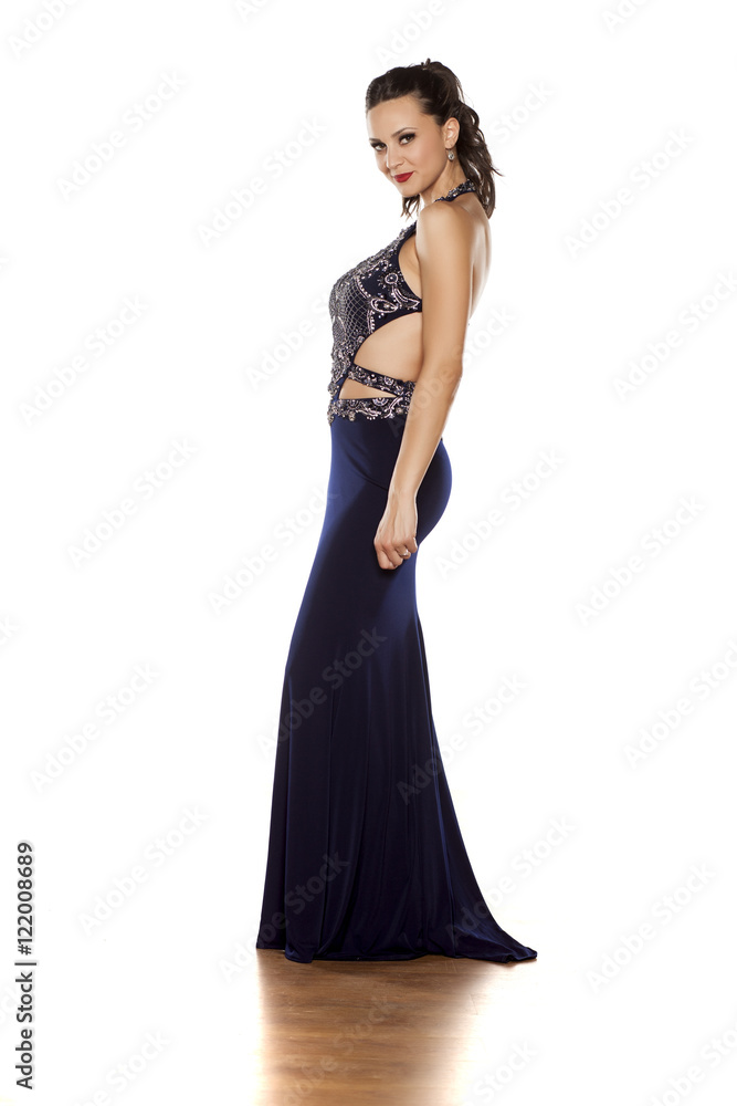 young beautiful woman posing in a long blue dress on a white background