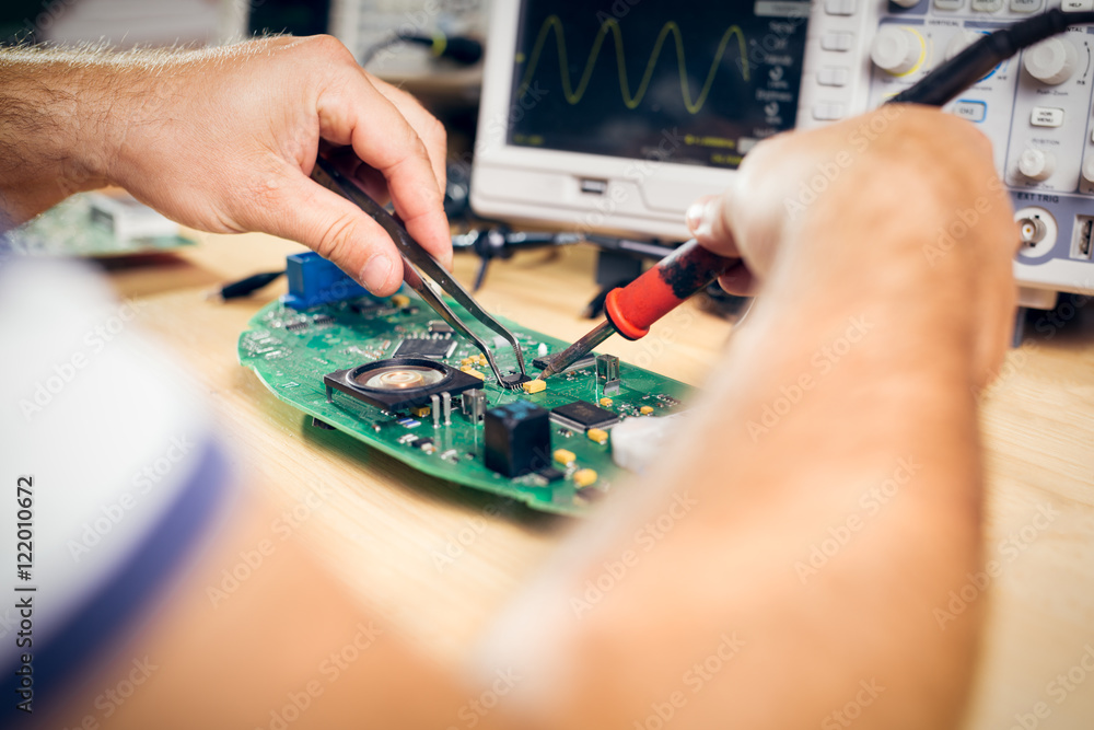 Tech tests electronic equipment in service center Tech tests electronic equipment in service center