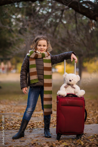 Wallpaper Mural a teenager girl in jacket and jeans plays in the autumn park with golden leaves Torontodigital.ca