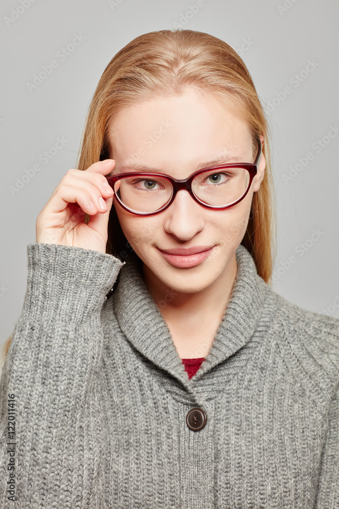 Junge attraktive Frau mit Hand an Brille