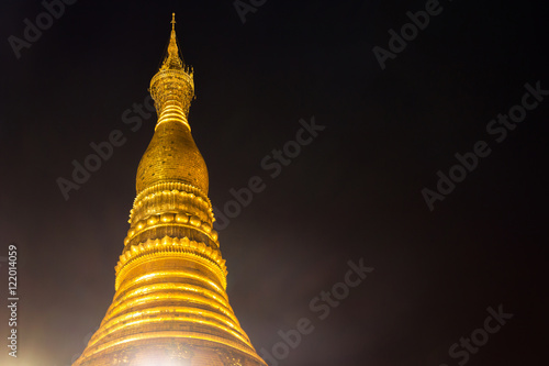 The top of Shwedagon pagoda at night with light up, famous sacred place in Yangon, Myanmar photo