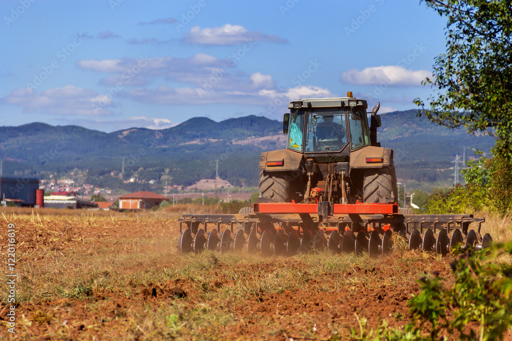 Fototapeta premium Tractor in a farmer field