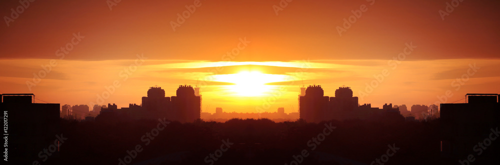 Fototapeta premium Beautiful evening cityscape. Aerial view. Skies, hazy sun, skyline, horizon. Selective focus. Special light. Wide panoramic image. 