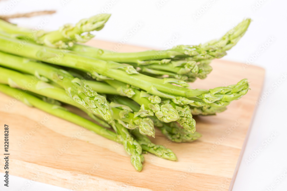Bunch of fresh asparagus on chopping board (soft focus) Bunch of fresh asparagus on chopping board (soft focus)