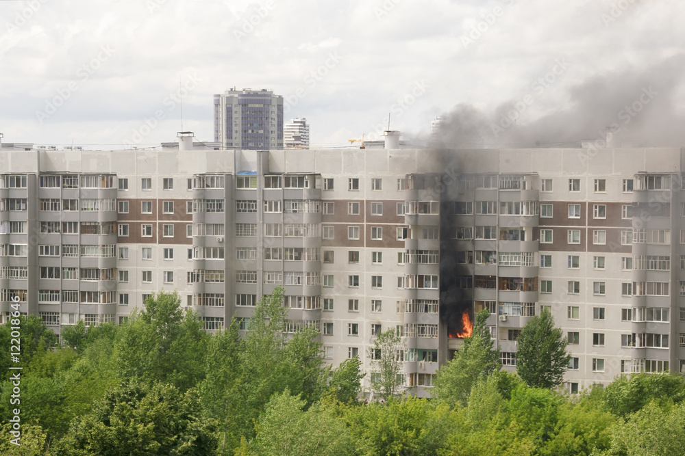 Fire with black smoke in multistory apartment building