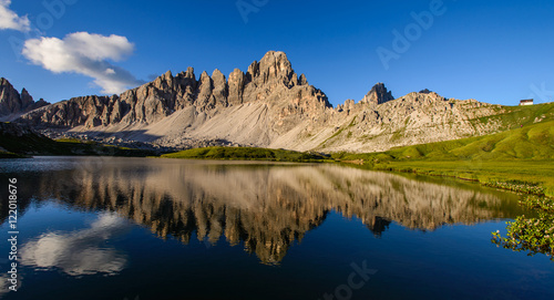 Famous mountain peaks of Tre Cime and their reflection on a still lake at sunset. Amazing Landscape of Dolomites range. Fantastic hike. Peaceful feeling.