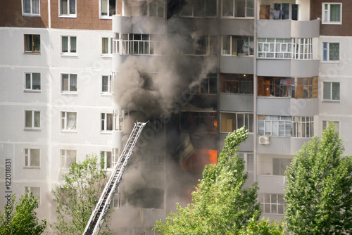 Firefighters extinguish a fire in multistory apartment building