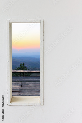 White wall window with sunset mountain view.