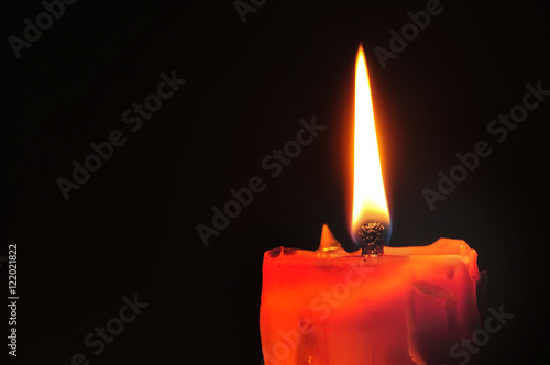 Red candle and lighting on black background