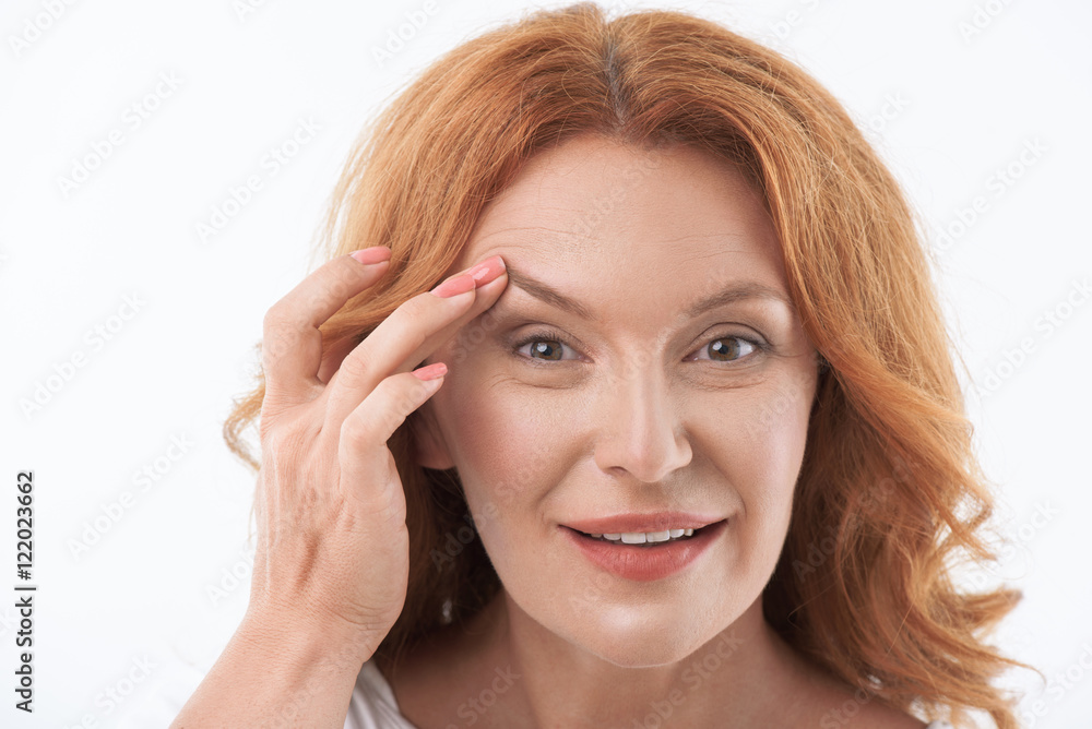 Cheerful middle-aged lady satisfied with skincare treatment Cheerful middle-aged lady satisfied with skincare treatment