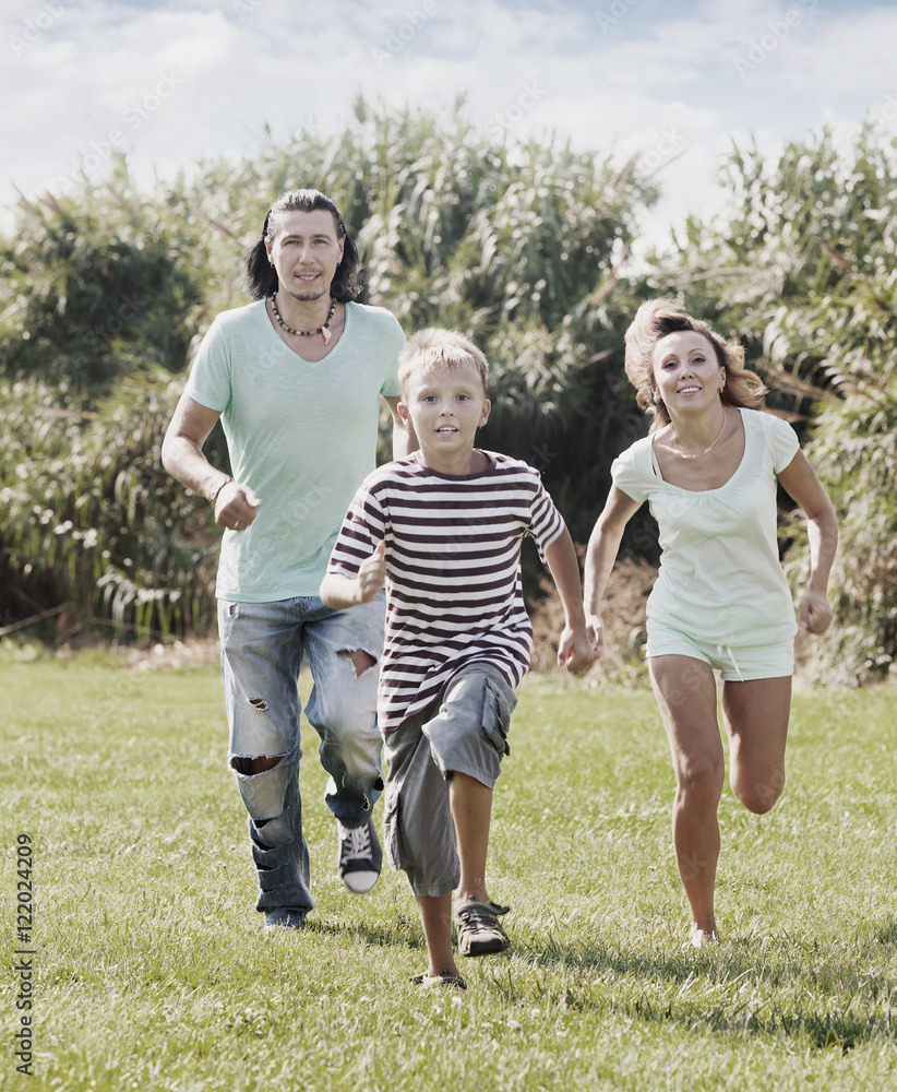  couple with child playing running  in summer