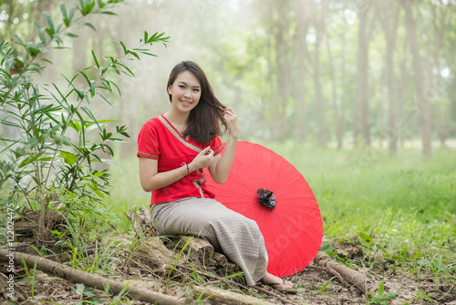 Beautiful Thai girl in Lanna traditional costume with red umbrel photo