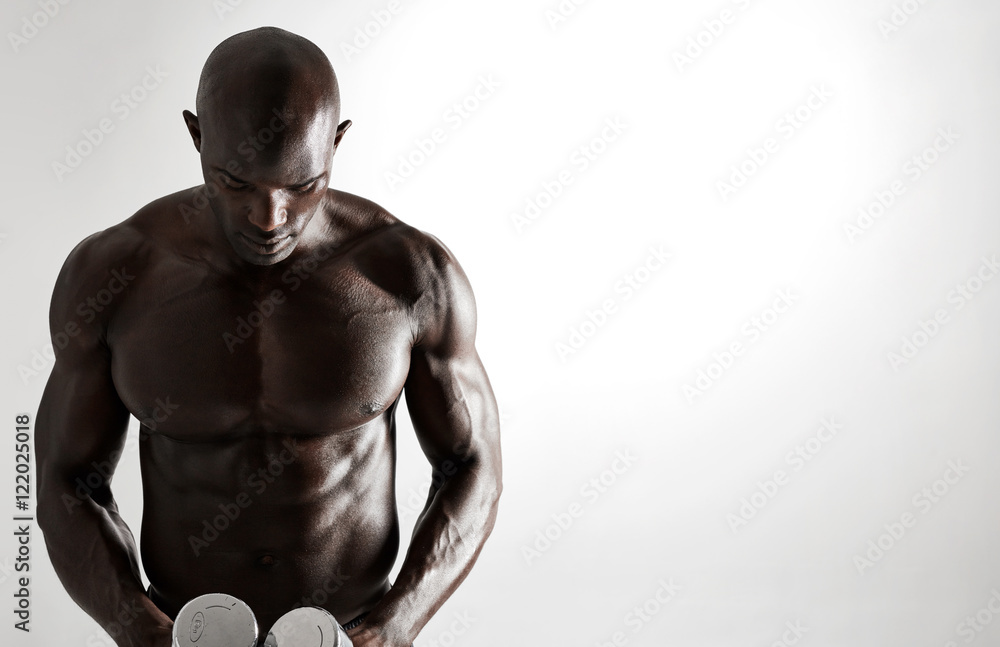 Fototapeta premium African male bodybuilder with dumbbells