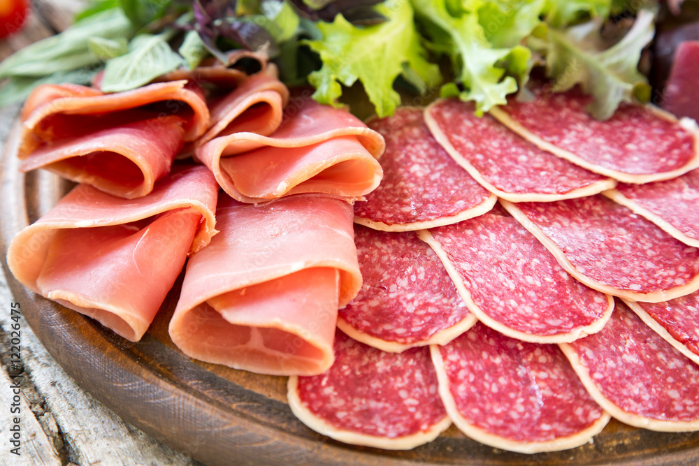 Antipasto with ham, salami and bresaola. tomato and basil. selec Antipasto with ham, salami and bresaola. tomato and basil. selec