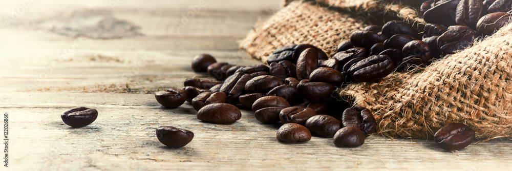 Roasted coffee beans on old wood background