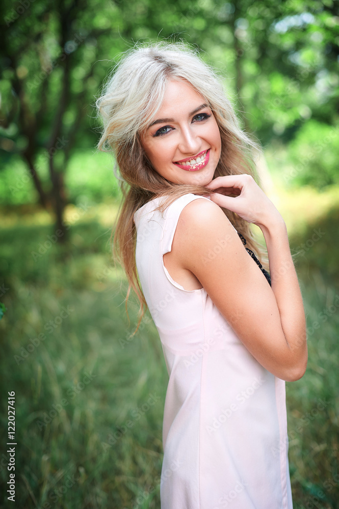 woman with long blond hair posing in summer park woman with long blond hair posing in summer park