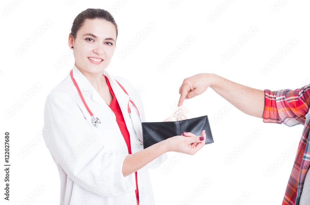 Patient hand putting money in female doctor wallet Patient hand putting money in female doctor wallet