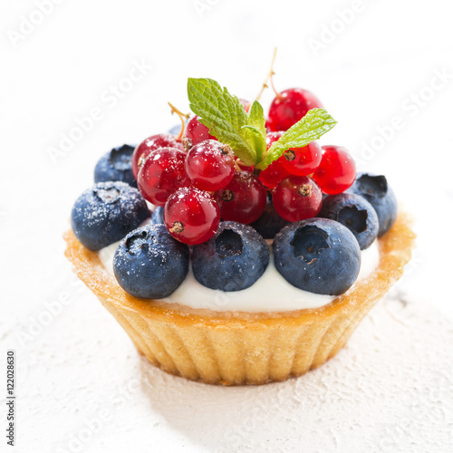 mini tart with cream and berries on white background, closeup photo