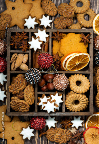 wooden box with Christmas sweets, nuts and spices, vertical 