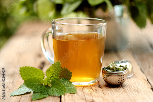 Billede på lærred A cup of melissa tea on wooden background