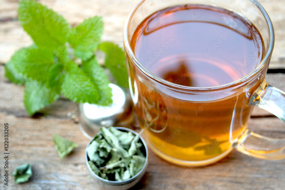 A cup of melissa tea on wooden background
A cup of melissa tea on wooden background