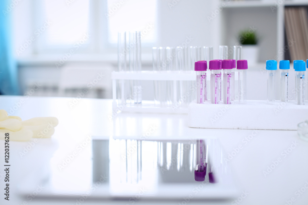 Research laboratory working space. Test tubes and tablet PC are lying at the table. Medical equipment. Blood test Research laboratory working space. Test tubes and tablet PC are lying at the table. Medical equipment. Blood test