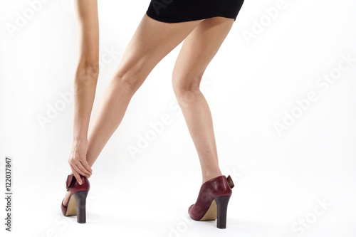 Woman legs wearing high heels on white background